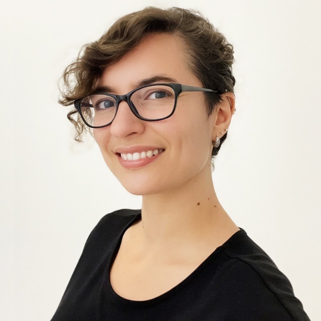 Luz, smiling, in glasses and a black top